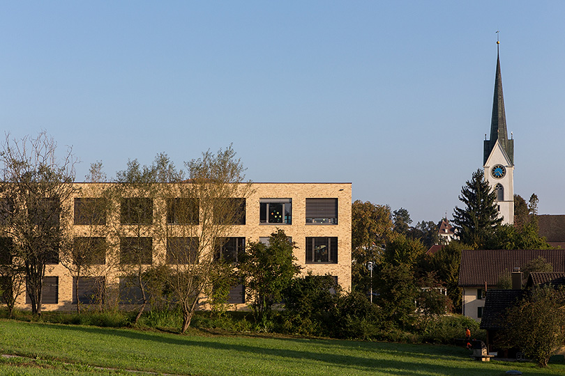 Schulhaus Hertimatt 3 und Reformierte Kirche