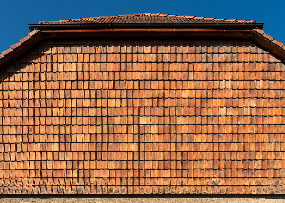 Mit Dachziegeln verkleidete Hausmauer