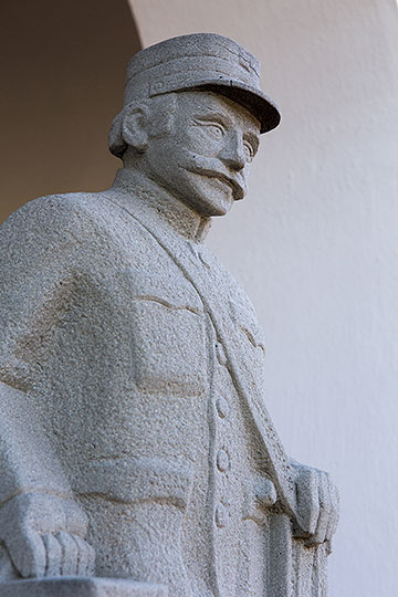 Steinskulptur eines Pöstlers bei der alten Post