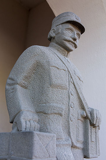 Steinskulptur eines Pöstlers bei der alten Post